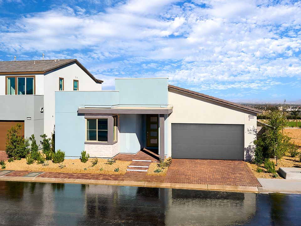 A modern, two-story house with a garage and a small pond in the foreground, set against a backdrop o