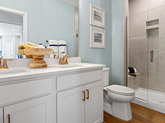 Owner s bath with dual vanity and step-in tiled shower in a DRB Homes Finch model at the Grandview E