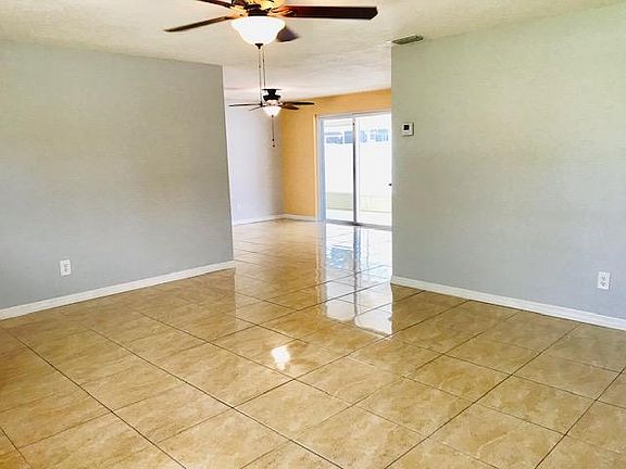 Living room looking into the dining area with sliding glass door