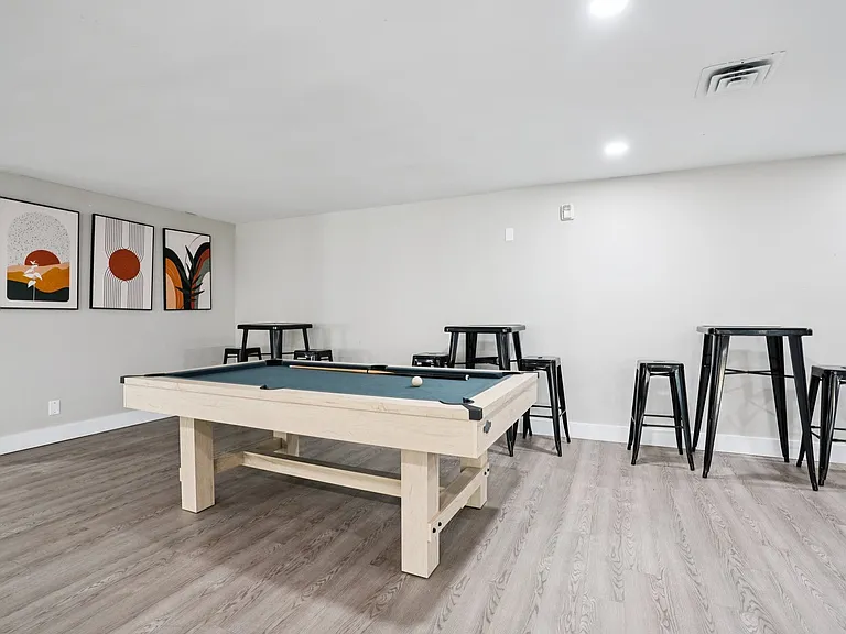 Enjoy friendly competition in our game room featuring a pool table and bar seating, professionally operated by Highlands Vista Group.