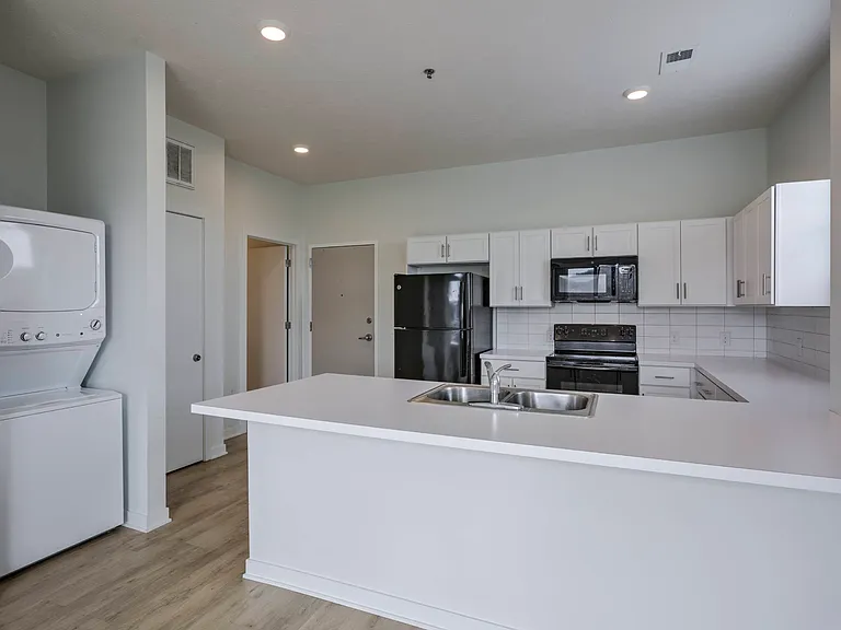 In-unit washer and dryer next to the kitchen in a unit at The Rise.