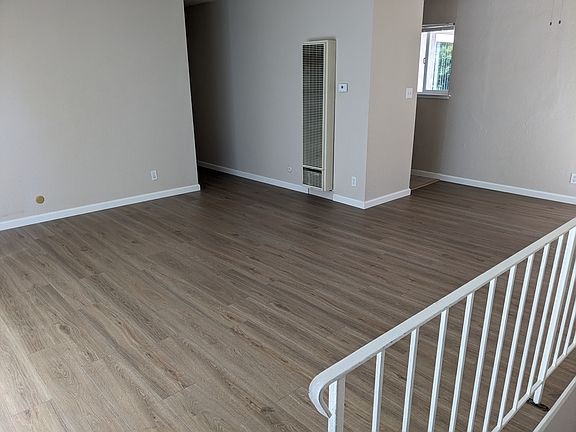 Family room/dining room combo with hardwood flooring and front balcony facing the street.