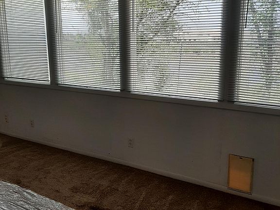 View of west wall of windows in family room, looking out onto Arkansas river and fenced backyard
