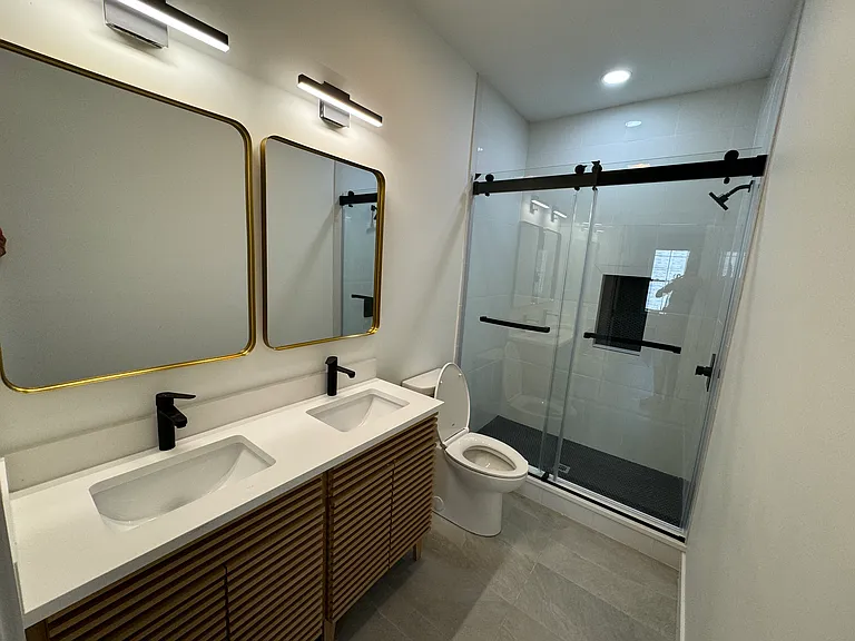 Master bath attached to master bedroom with double vanity and tiled shower.