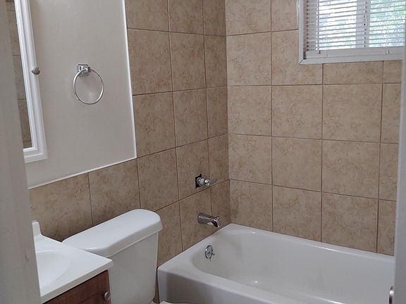Bathroom with New tub, tub surround, toilet, sink & cabinets.