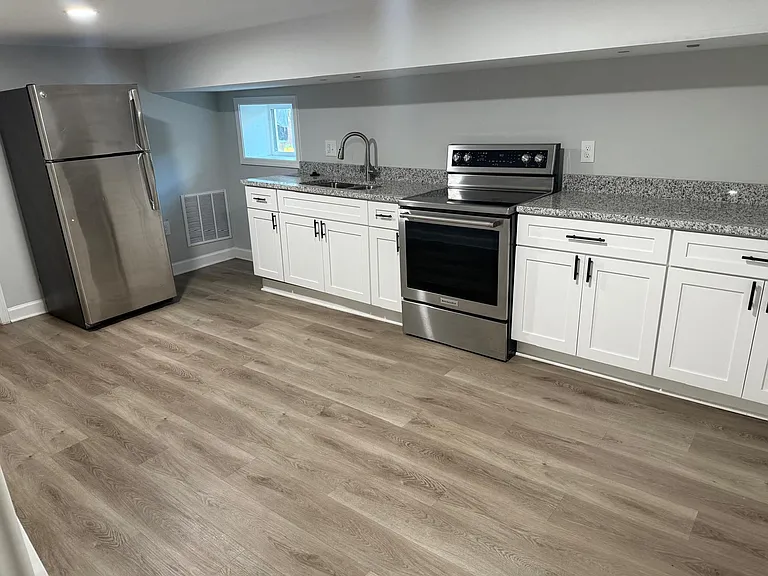 Updated kitchen with stainless appliances, granite-look counters, ample cabinetry, and a window over the sink.