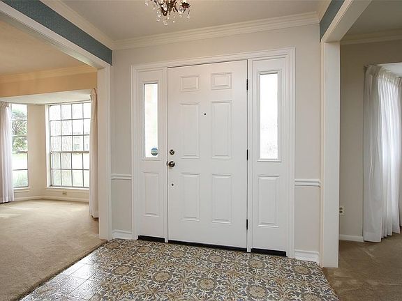Entry showing the recent front door and side panels and bay windows in formals