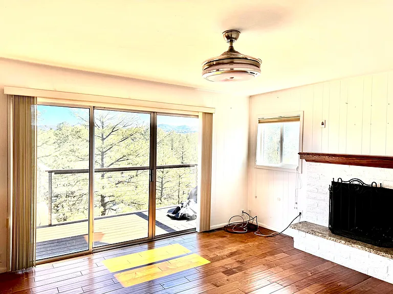 Family room off the kitchen. Room for large sectional plus another large uphostered chair. Natural wood burning fireplace. The ceiling fixture opens into a fan, when turned on.