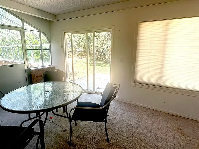 Sunroom with greenhouse/atrium to the left; and sliding door to back yard