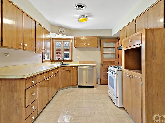 The kitchen features a gas stove and a lightly used dishwasher. There is a large refrigerator on the