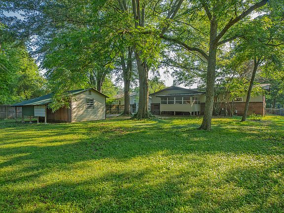 Very large fenced back yard with extra storage behind shop.