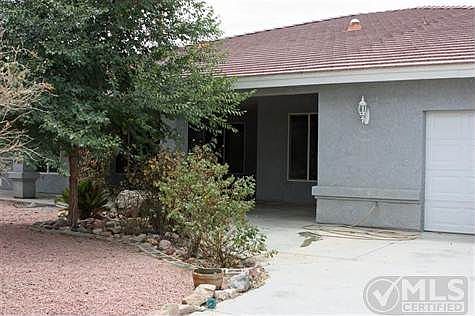 The front of the home, encased in a front patio and double entry.