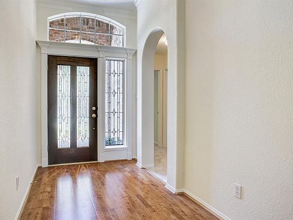 Beautiful lead glass front door opens onto hardwood foyer.