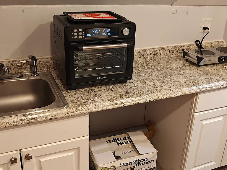 Kitchen Sink, cabinets, toaster Oven/Air Fryer and Hot plate