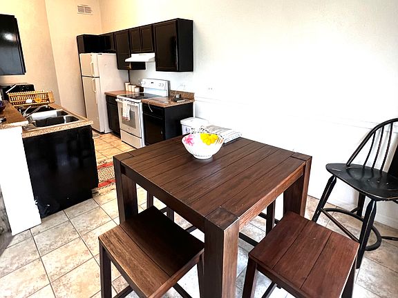 Kitchen and dining area opening into living room with area for bar stools