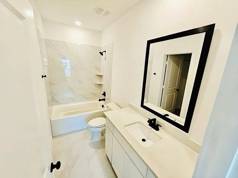 Bathroom with vanity, marble finish floors, shower combination, and recessed lighting