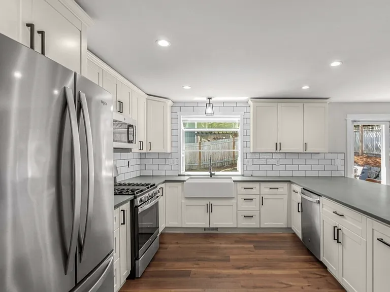 Updated kitchen with stainless appliances. Subway tiles, farmhouse style kitchen sink