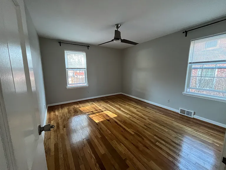 Bedroom with ceiling fan and curtain rods provided