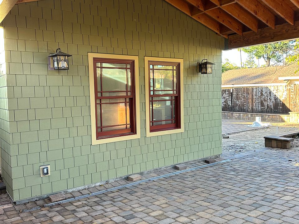 Covered carport with Belgard tiles and craftsman lighting