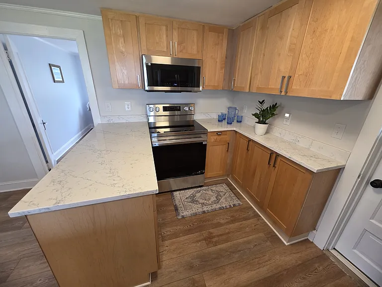 Updated kitchen has peninsula and convenient quartz countertops