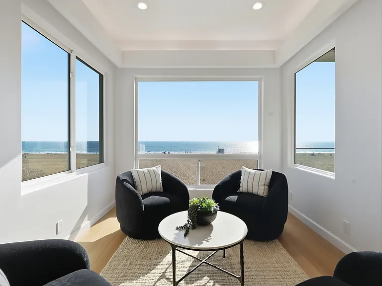 The main living room features breathtaking panoramic views from every corner, covered balcony, bar, and powder room.