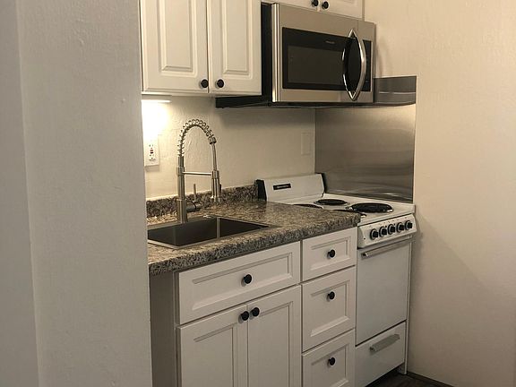 Kitchen with new cabinets, microwave, and sink.