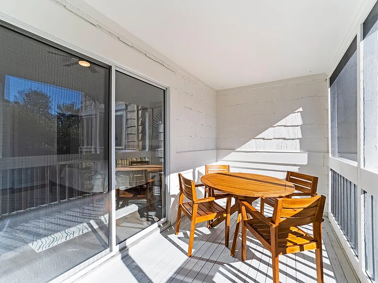 Screened in patio with dining table off the primary bedroom.