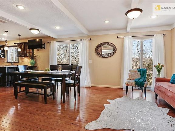 Hearth room and eat-in space adjoin the kitchen; note sliding doors to one level of deck that spans back of home.