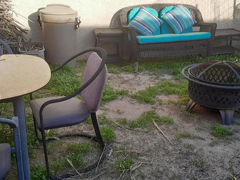 Fire pit, charcoal grill, solar oven, firewood, table and 3 chairs, and outdoor sofa.