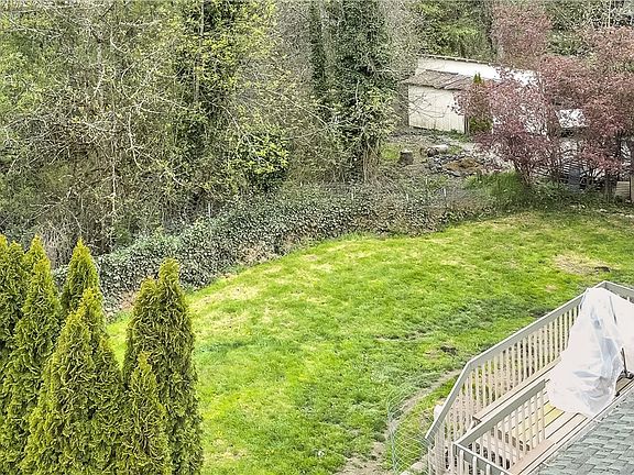 View from other back corner showing ample back yard leading to seasonal pond & outbuildings. 