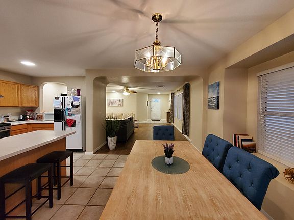 View of dining area and kitchen with great room in background. Dining area has bay window seating area.
