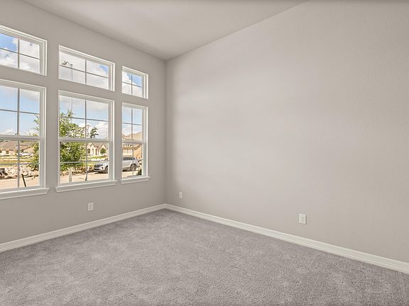 The secondary bedroom features plush carpet, fresh paint and large windows allowing for plenty of su
