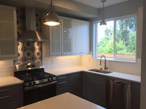 kitchen w/ gas range and hood vent