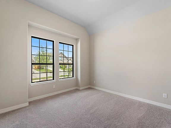 The secondary bedroom features plush carpet, fresh paint, closet, and a large window that lets in pl