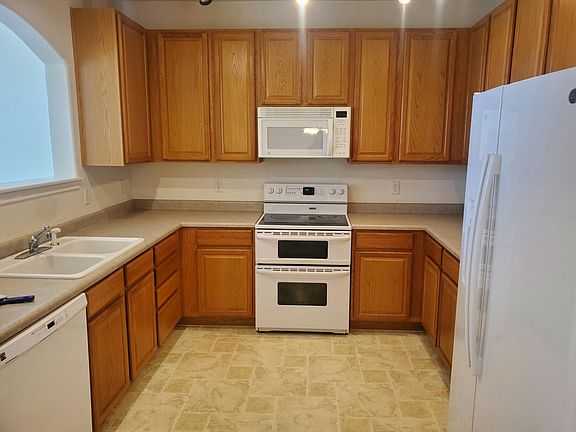 Kitchen with electric range and garbage disposal in the sink.