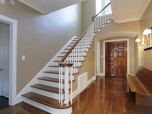 Staircase with large windows at top - high ceilings. Beautiful wood floors.