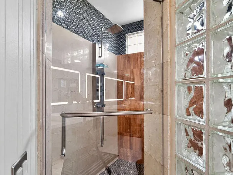 Custom stone & glass shower w/waterfall, body jets and bench
