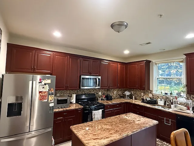 Large kitchen with granite counter top and whirlpool / kenmore appliances
