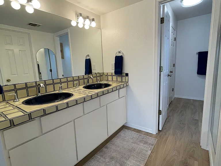 Primary Bedroom's double-sink vanity area with separate shower/tub and toilet area