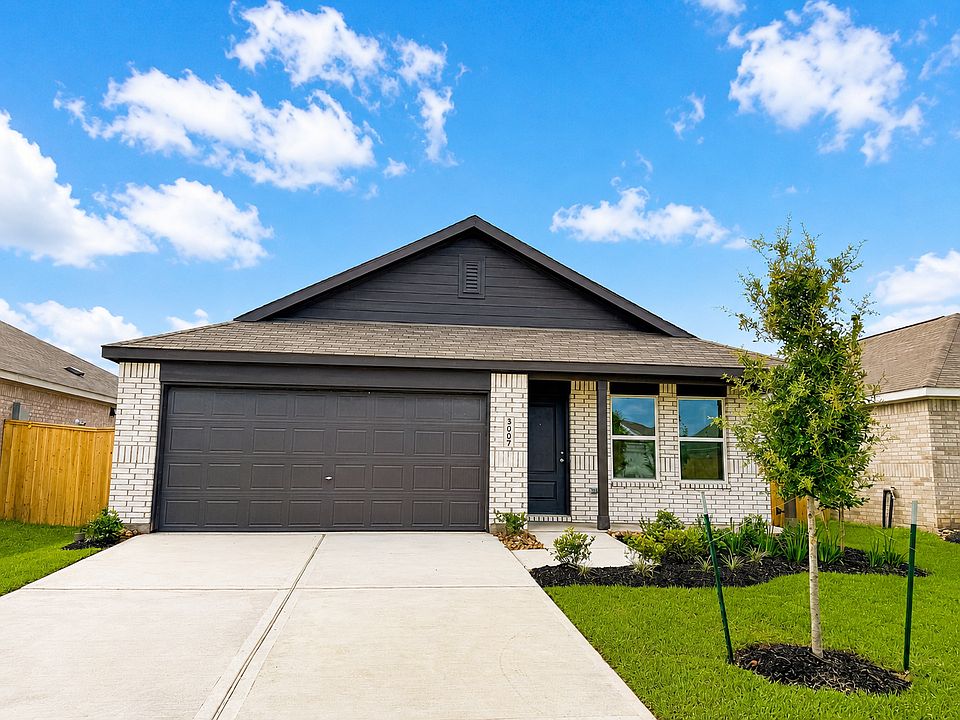 Modern curb appeal featuring a spacious two-car garage, oversized driveway, and professionally landscaped front exterior.