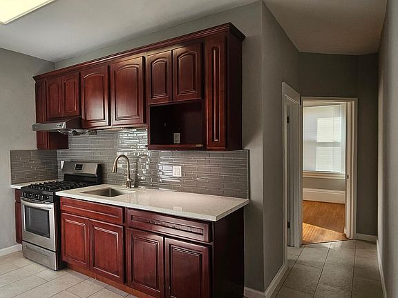 Natural light provided by adjacent window. Kitchen leads into the bathroom.