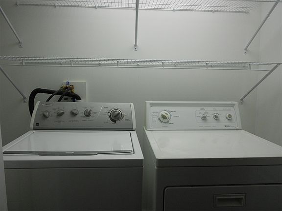 Lighted Laundry area with storage shelves