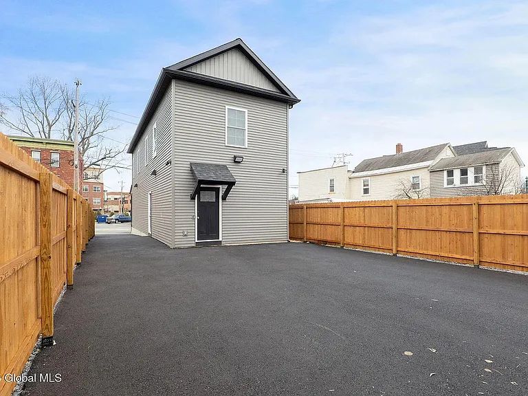 Parking area, secured with fence, motion-detected lighting, and security cameras.