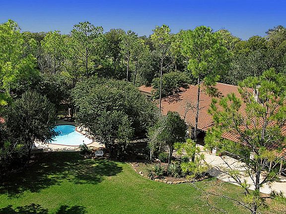 This view captures the grandeur of the back of the home and showcases how the forest provides complete privacy.  It also offers a glimpse of the pool and the distinctive Mediterranean style tile roof