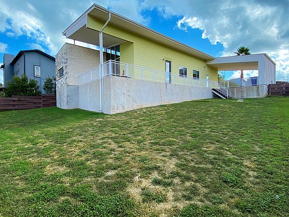 Back of home showing elevation and wrap around balcony.