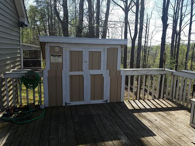 Rear deck locker; two-level: on the deck level, one can store a grill out of the weather. From the ground level, there's room for mower and yard-tool storage.