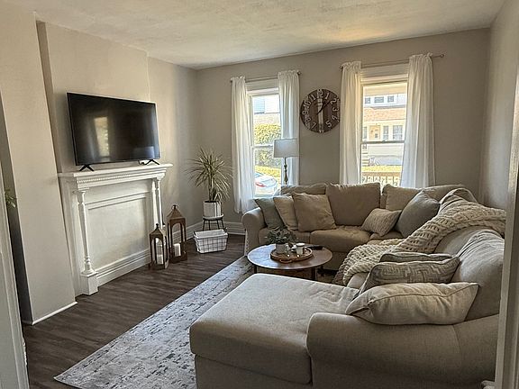 Spacious living area with high ceilings and a mantle for TV