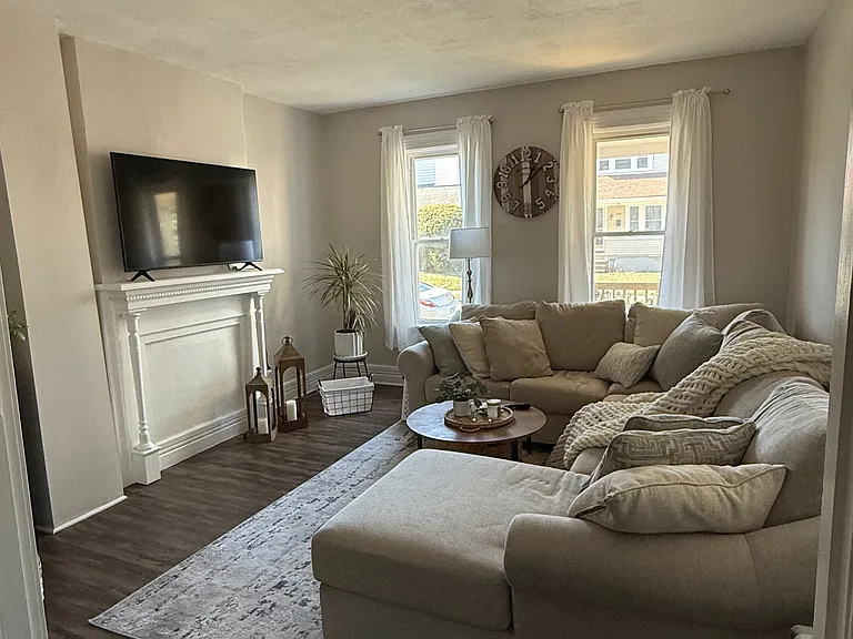 Spacious living area with high ceilings and a mantle for TV