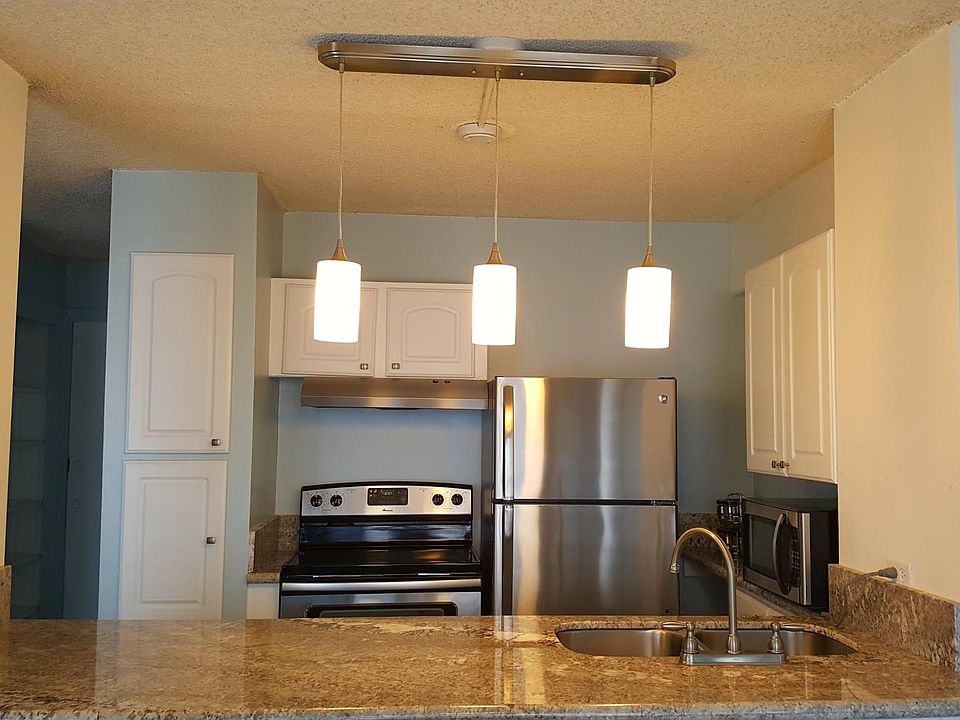 Kitchen with stainless steel fridge/oven and granite countertop,