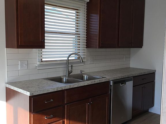 Kitchen has new cherry cabinets, subway tile, deluxe appliances, sink and faucet.